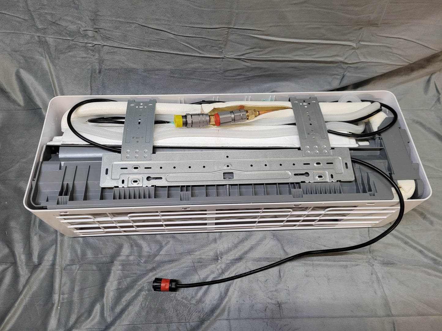 The back of the indoor unit has the quick connectors which attach to the outdoor unit, as well as the pre-installed communications control cord to attach to the outdoor unit.
